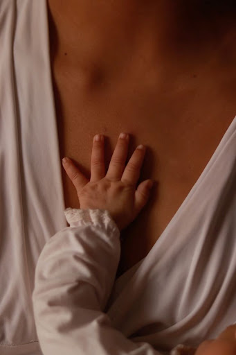 La mano de un bebé sobre el pecho de su madre